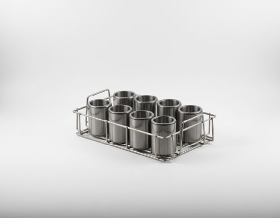 Stainless steel wire basket holding eight cylindrical metal cups arranged in two rows of four, on a grey gradient background