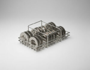Stainless steel wire basket holding multiple flat circular metal disc components arranged in upright rows, on a grey gradient background
