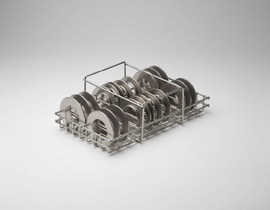 Stainless steel wire basket holding multiple flat circular metal disc components arranged in upright rows, on a grey gradient background