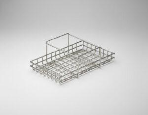 Shallow stainless steel wire mesh basket with a raised handle divider on one end and grid base, on a grey gradient background